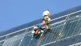 Arbeiter klettern auf Glasdach um es zu sanieren
